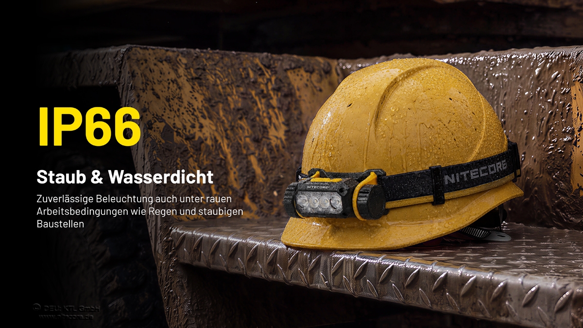 Ein gelber Schutzhelm mit angebrachter Nitecore-Stirnlampe, der auf einer schlammigen Metalloberfläche mit dem Text „IP66-Bewertung“ ruht.