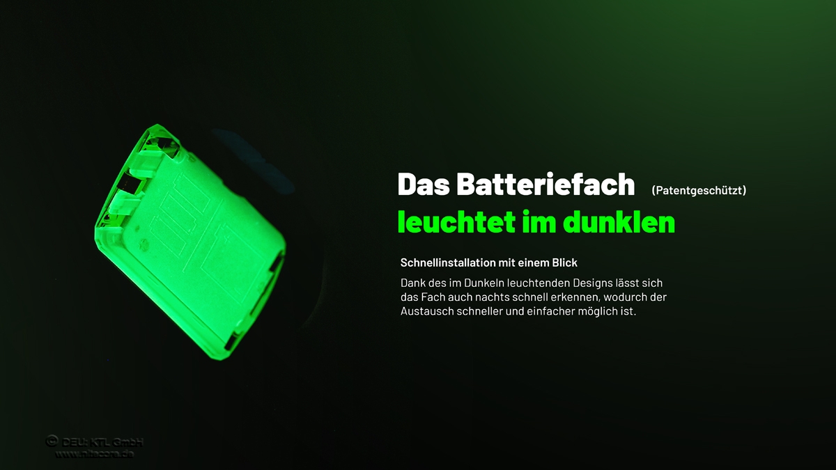 Eine leuchtend grüne Batteriefachabdeckung im Dunkeln, die ihre Sichtbarkeit für einen einfachen Austausch hervorhebt.